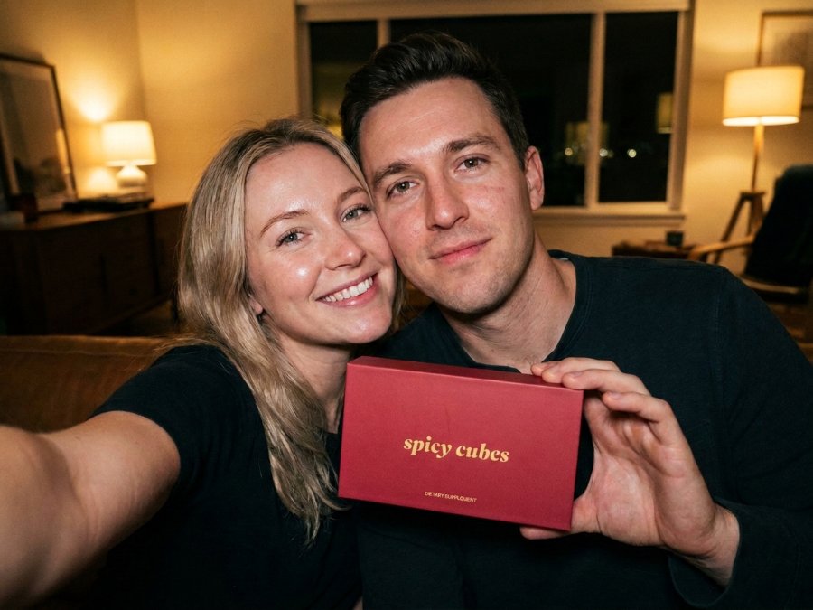 A couple on a sofa holding up the red Spicy Cubes box